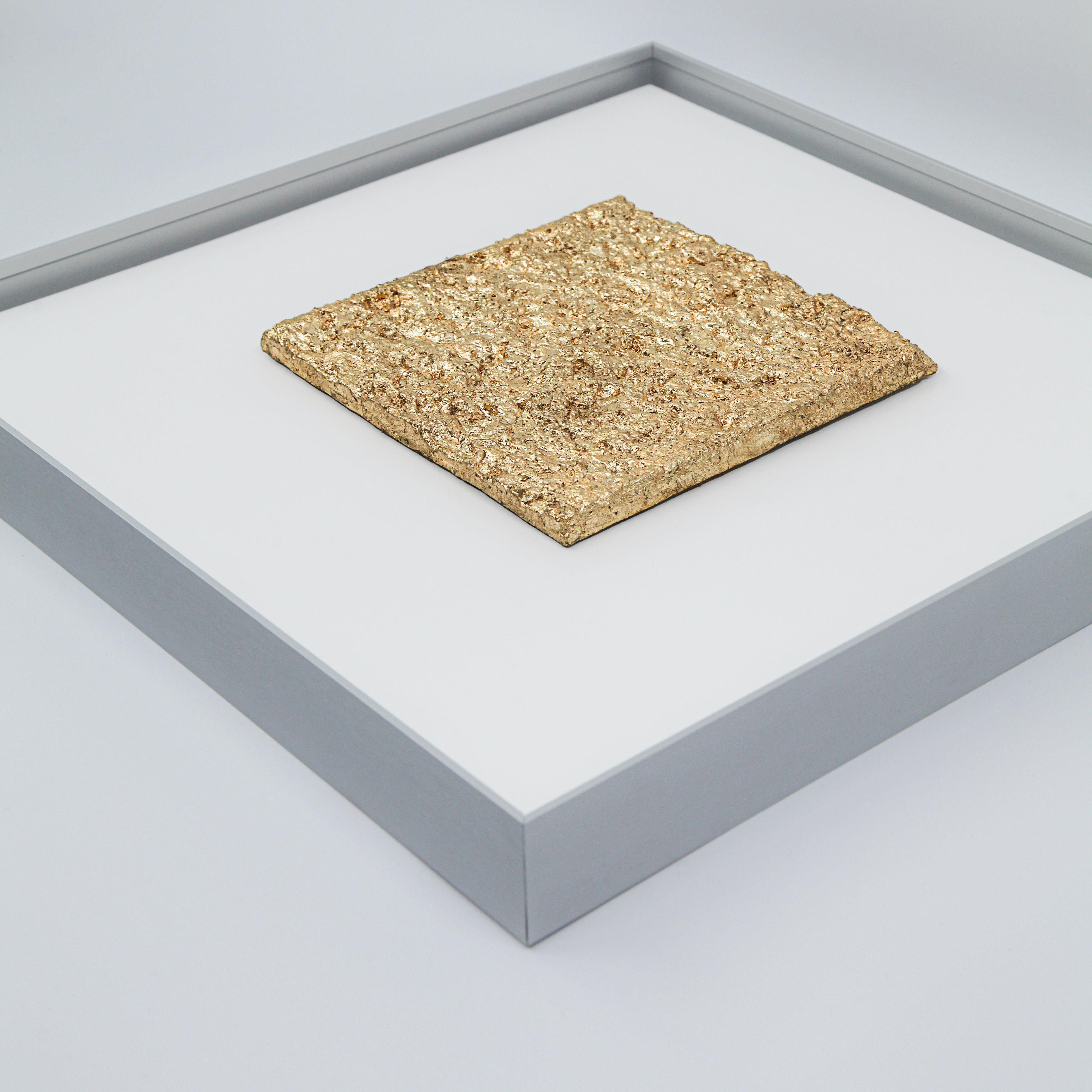 Flat-lay overhead view of Solstice — Gilded Foil · Aura Frame, capturing the full topographic expanse of its fire element mineral terrain — hand-modeled mountain ridgelines receding toward the horizon, gilded foil spreading across every peak like gold light at the moment of solstice.