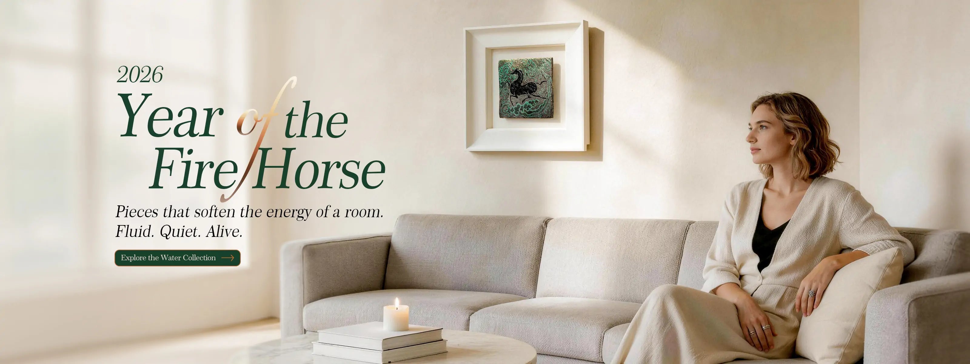 A serene living room featuring AetherCanvas 2026 Year of the Fire Horse collection. A woman sits peacefully on a sofa next to a framed textured mineral art piece, symbolizing fluid and calming energy for home and office decor.